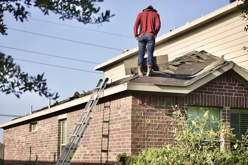 Professional roofer working on a residential roof in Brinkley Estates